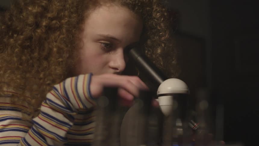 Girl looking through a microscope