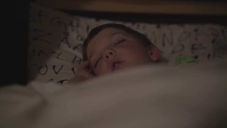 Young boy sleeping in bed