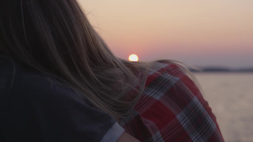 A couple watching the sunset on a beach