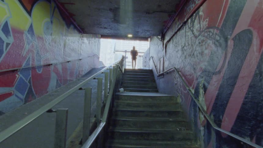 Someone is walking up a staircase filled with graffiti
