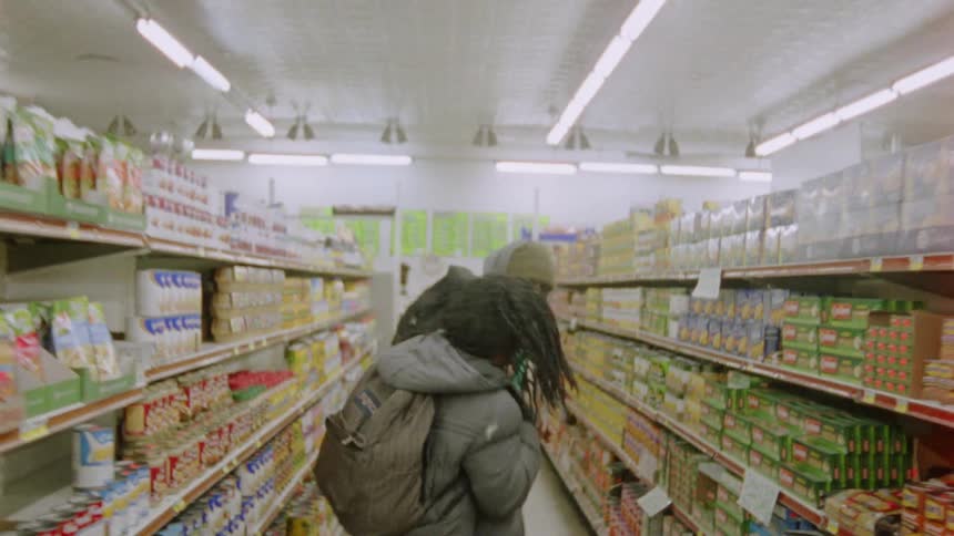 Two men play fighting in a grocery store