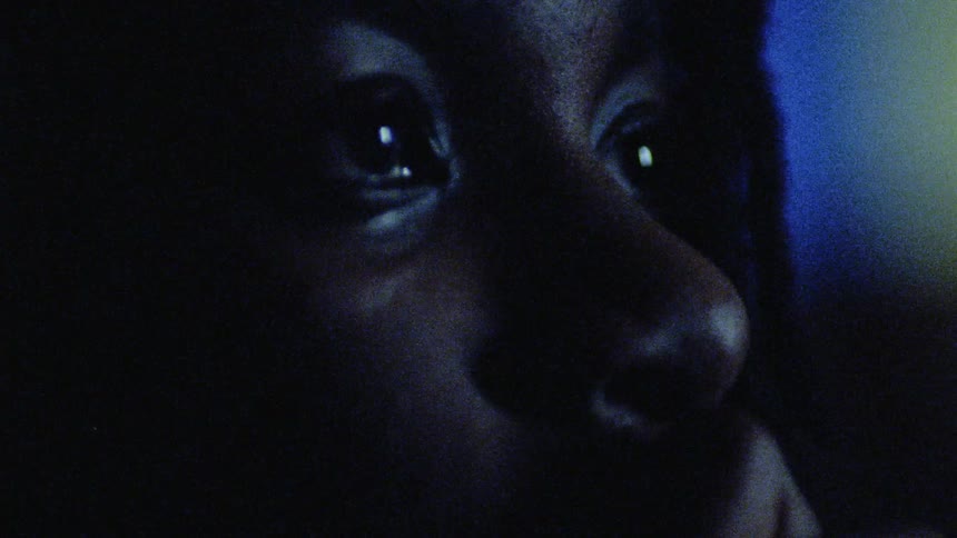Lights are flashing on a boy's face as he looks up