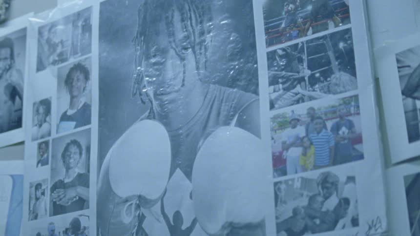 Pictures are placed on a wall of a man wearing boxing gloves