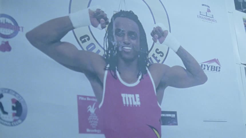 A poster of a boxer flexing and holding his hands up