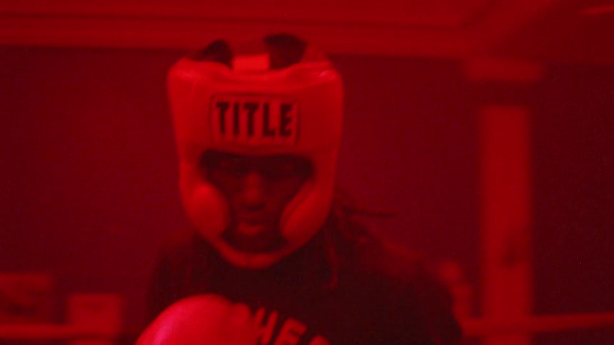 Man stands in a boxing ring pacing in circles