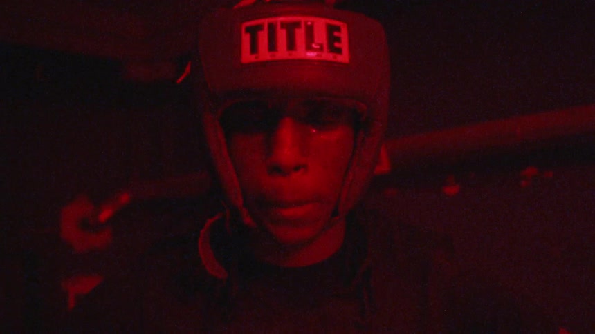 A boxer readies himself under flashing red lights