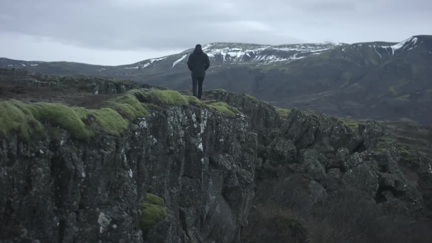 A person walking on a cliff edge