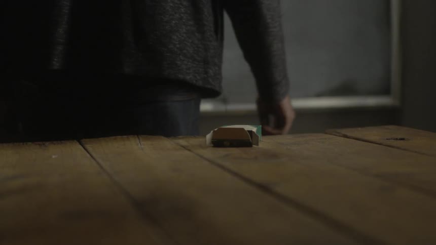 Man picks up chalk from a table and turns to a blackboard
