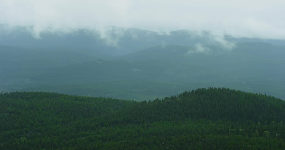 Clouds cover mountain tops and come across to the valley