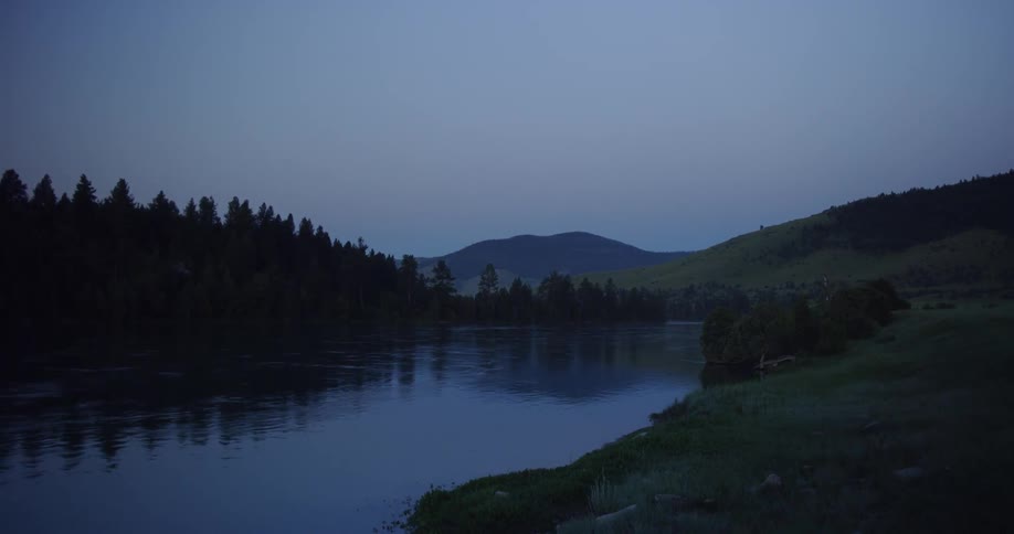 A river flows through a forest at dusk