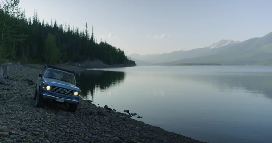A car is driven on a mountain lakeshore