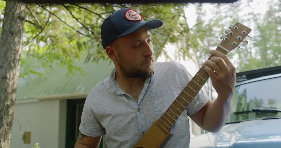 A man plays a unique shaped guitar