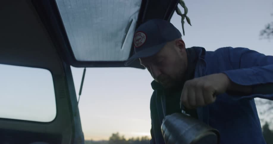 Water is being poured into a cup in the back of a car