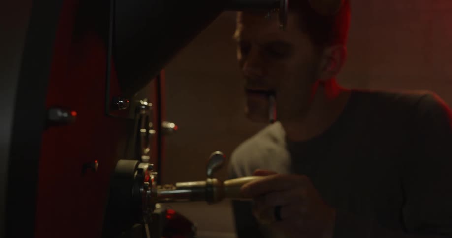 A man is checking a machine in a warehouse
