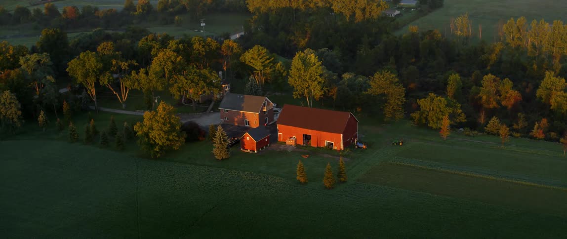 Aerial view of a farm in the country with a big red barn