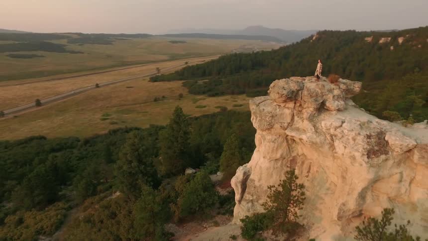 A woman stands on top of a ridge