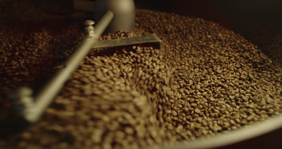 Coffee beans are being stirred by a machine