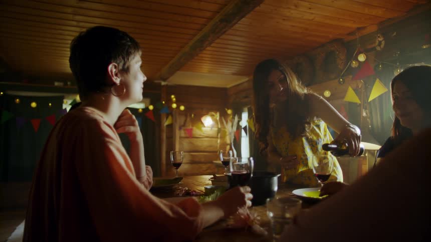 People are talking around a table and pouring drinks