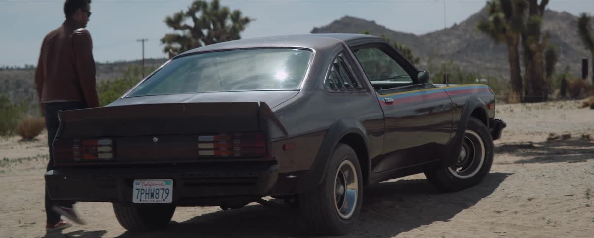 Man walks towards sports car on sand