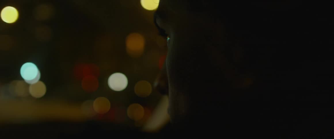 A man rides in a vehicle at night