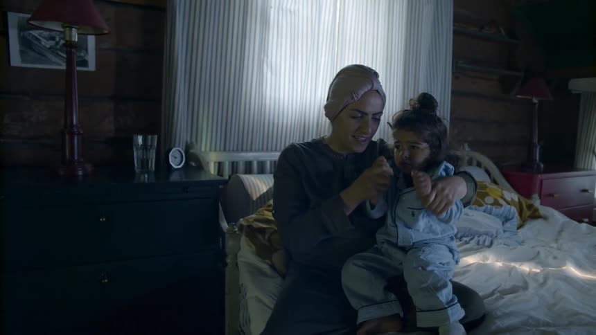Woman comforts a crying child on a bed