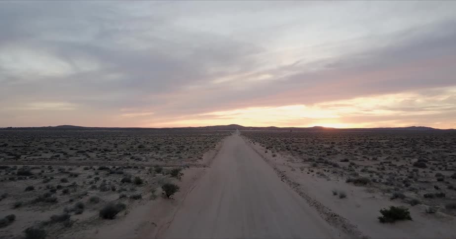 Flat desert road during sunset