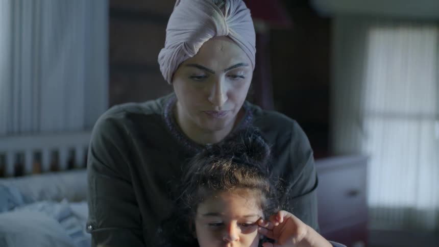 A woman and child flip through a book