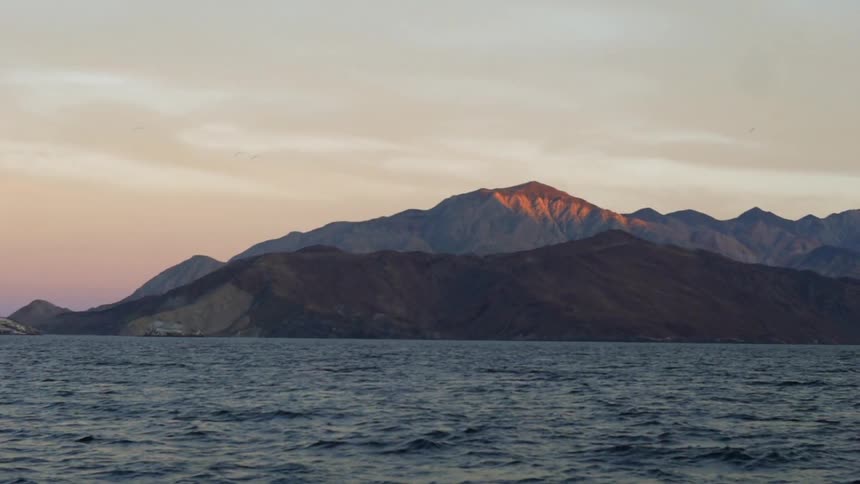 Mountains surround a lake at sunset
