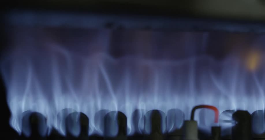 A flickering blue flame coming from a gas burning stove