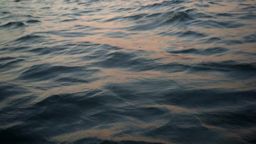 Waves move softly under the setting sun