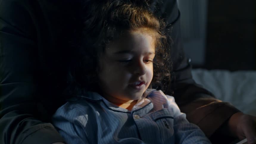 Woman and child are reading a book indoors