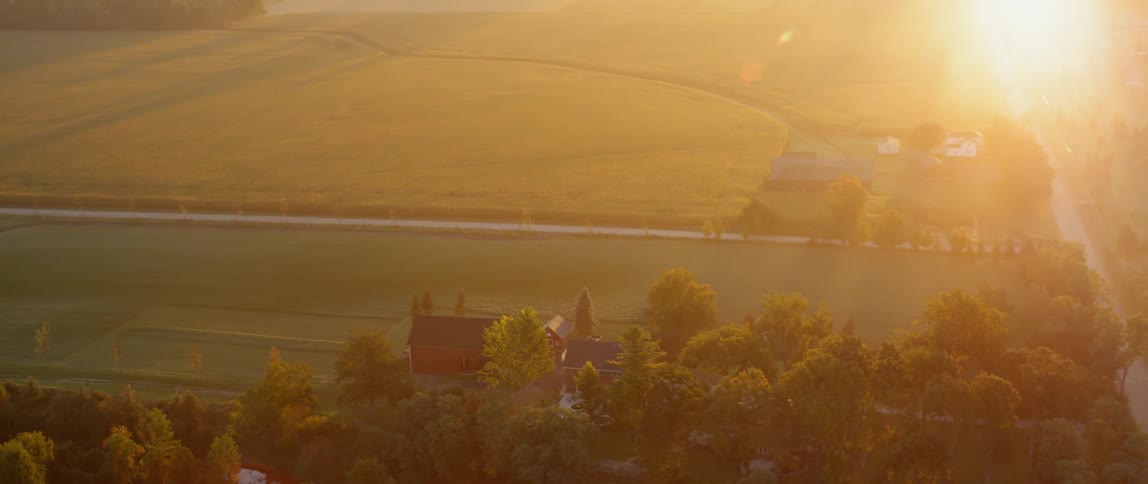 The sun sets over a rural farm