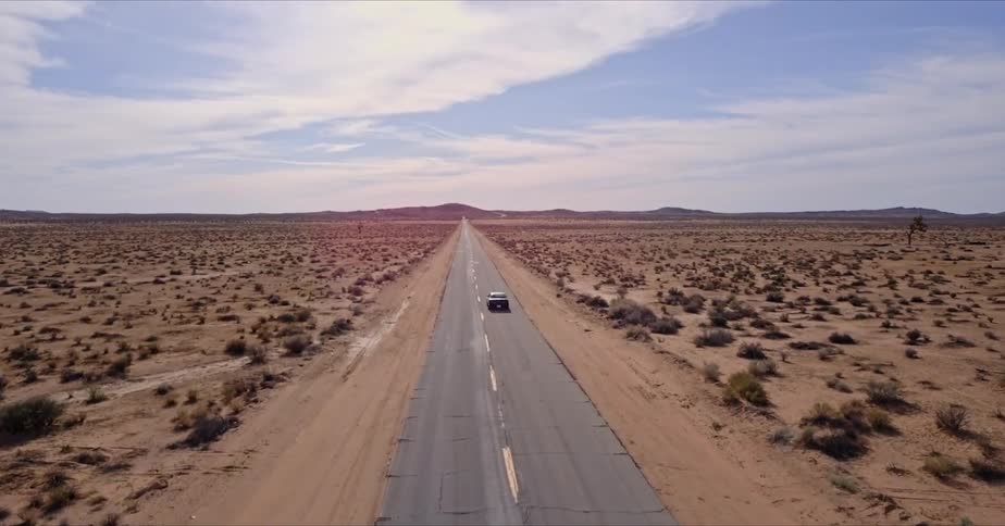 A car drives down the desert highway