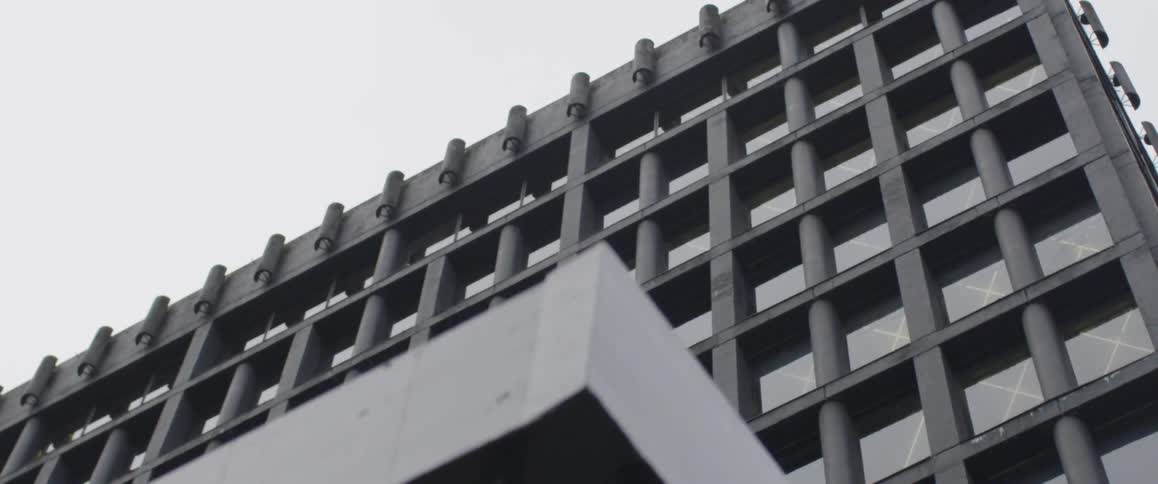 A modern building stands behind iron gates
