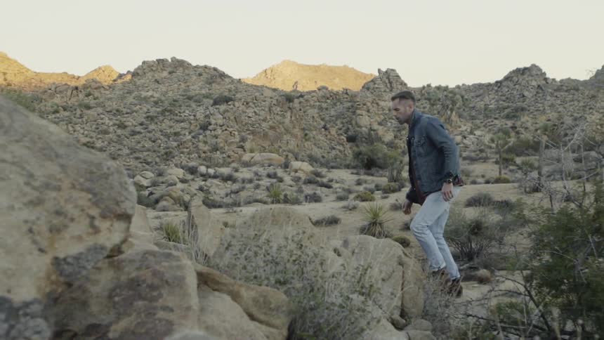 A man is walking by a mountainside