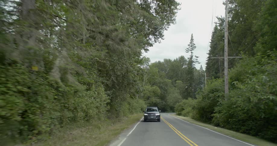 A car is driving on a road during daytime