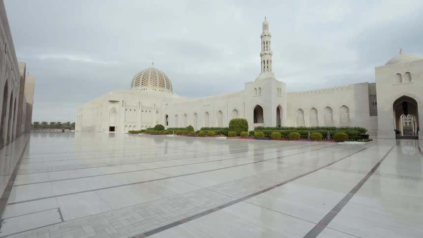 A marble floor leads to pristine religious buildings complete with a dome and minaret