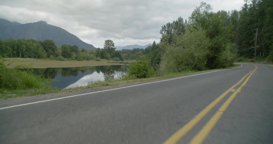 Car driving down a road at mountains