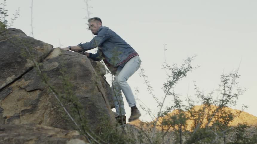 Man climbs rocky cliff