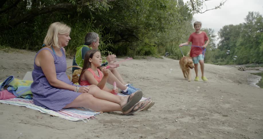 A family of five having a picnic near a river
