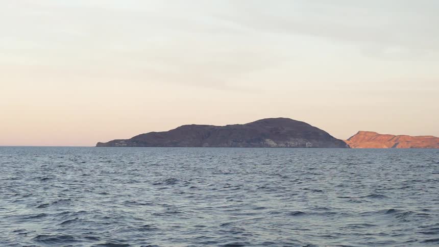 Large body of water surrounding small mountains
