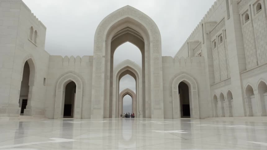 Symmetrical arches mark the entrance to a majestic marble mosque
