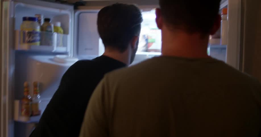 Two men looking in the refrigerator