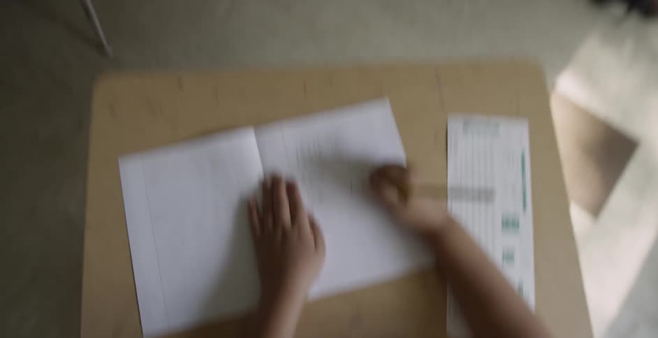 Children are in a classroom writing in notebooks