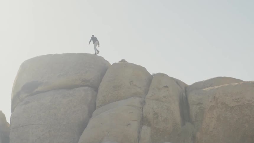 A man jumps hiking on the top of the mountain