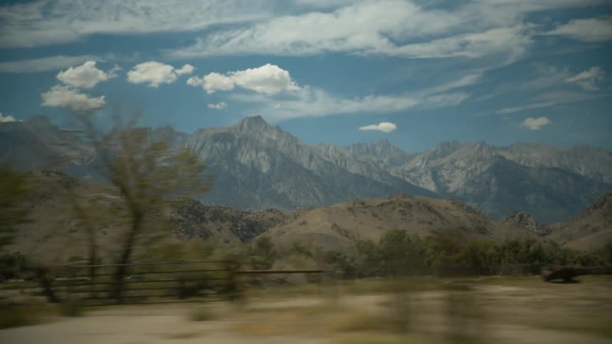 A scenery of a grassland and mountain range