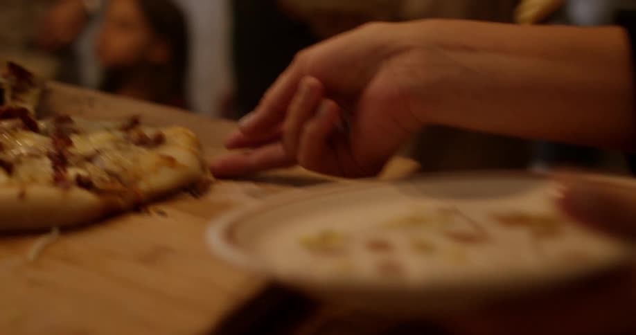 People grabbing pizza slices
