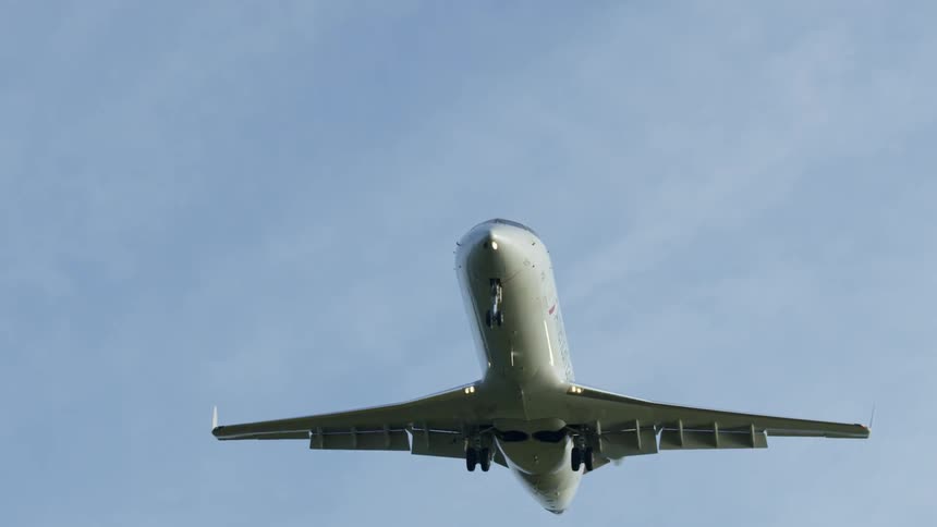 The large plane flies past the clouds