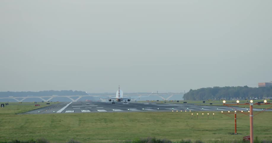 A plane lands on the runway in the daytime
