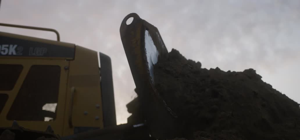 Closeup of a bulldozer pushing dirt into a pile